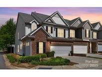 Charming townhome boasts a brick facade, attached garage, and professionally landscaped front yard at 5908 Glassport Ln, Charlotte, NC 28210