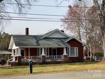 Charming brick bungalow-style home with a covered front porch and white railings at 8350 Nc Hwy 90 E Hwy, Stony Point, NC 28678