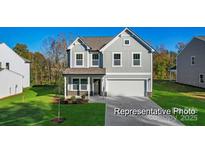 Charming two-story home featuring a manicured lawn and a classic gray facade at 9913 Jack Nicklaus Dr # 908, Lancaster, SC 29720