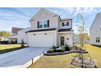 Charming two-story home featuring a well-manicured lawn, attached garage, and welcoming front entrance at 10031 Travis Floyd Ln, Charlotte, NC 28214