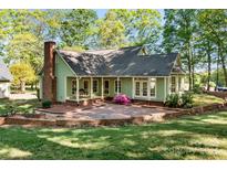 A charming home with a brick chimney, surrounded by lush trees and landscaping at 101 Blueberry Hill Dr, Statesville, NC 28625