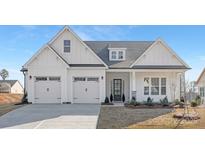 Charming two-story home with a three-car garage, stylish front door, and a well-manicured lawn at 13097 Arnold Palmer Cir # 844, Lancaster, SC 29720