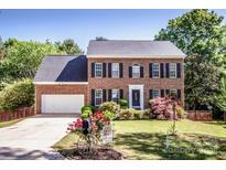 Two story brick home with an attached two car garage and manicured front lawn at 145 Meadow Pond Ln, Mooresville, NC 28117