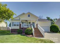 Charming yellow home with a welcoming front porch and well-manicured lawn at 1488 Meadow Glen Ln, Rock Hill, SC 29730