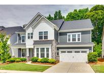 Charming two-story home with a manicured lawn and a two-car garage, showcasing its appealing curb appeal at 15312 Ravenall Dr, Huntersville, NC 28078