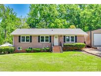 Charming brick ranch-style home featuring a manicured lawn, classic black shutters, and an inviting front entrance at 1540 Neely Store Rd, Rock Hill, SC 29730