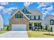 Charming two-story home with a well-manicured lawn, brick accents, a two-car garage and welcoming front porch at 17231 Rider Wood Ln, Charlotte, NC 28278