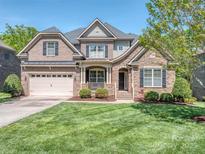 Inviting two-story brick home with a well-manicured lawn and charming curb appeal on a sunny day at 4008 Widgeon Way, Waxhaw, NC 28173