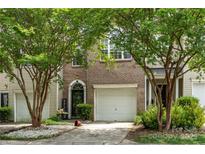 Charming townhouse featuring brick accents, a one-car garage, and a welcoming front entrance at 5310 Glenlea Walk Ln, Charlotte, NC 28216
