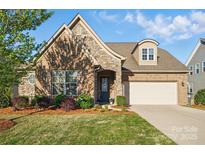 Charming brick and stone home with well-manicured lawn and a welcoming entrance, including an attached two-car garage at 9565 Horsebit Ln, Concord, NC 28027