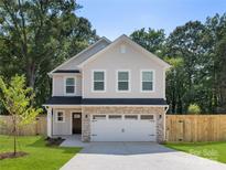 Charming two-story home featuring a brick-accented garage, manicured lawn, and privacy fence at 1141 Thayer Glen Ct, Charlotte, NC 28213