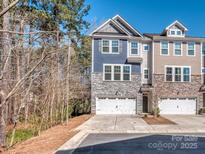 Charming townhome showcasing stone accents, a two-car garage, and a well-manicured lawn at 12214 Ardrey Park Dr, Charlotte, NC 28277