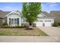 Charming single Gathering home featuring a two-car garage and a beautifully landscaped front yard at 13115 Union Square Dr, Huntersville, NC 28078