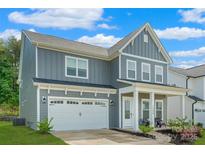 Charming two-story home featuring a two-car garage, covered porch and manicured lawn in a Gathering-friendly neighborhood at 1390 Cedardale Ln, Denver, NC 28037