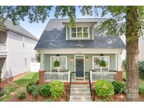 Charming home featuring a welcoming front porch, landscaped yard, and classic architectural details at 14541 Holly Springs Dr, Huntersville, NC 28078