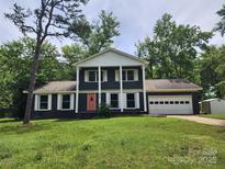 Inviting home boasts traditional charm, a two-car garage and a front yard lush with mature trees at 1620 Matthews Dr, Rock Hill, SC 29732