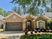 Charming brick home with a well-manicured lawn and inviting two-car garage, under a sunny blue sky at 17408 Summer Place Dr, Cornelius, NC 28031