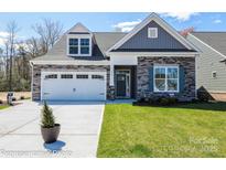 Charming single-Gathering home with stone accents, lush green lawn, and an attached two-car garage at 2007 Mantle Ridge Dr # 192, Indian Trail, NC 28079