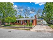 Charming brick home with well-manicured lawn, red front door, and covered carport at 218 N Bost St, Statesville, NC 28677