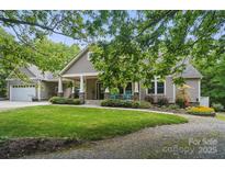 Charming home featuring a spacious front porch, well-manicured lawn, and beautiful landscaping at 4561 Walden Pond Trwy, Concord, NC 28025