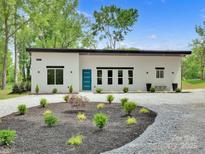 Stunning modern home featuring a clean design, blue door, and meticulously landscaped front yard at 6907 Lancaster Hwy, Waxhaw, NC 28173