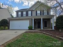 Charming two-story home featuring a brick facade, two-car garage, and inviting front porch at 8323 Carolina Laurel Ct, Charlotte, NC 28215