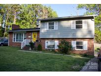 Charming brick home with a bright yellow door and well-maintained lawn at 920 Squirrel Hill Rd, Charlotte, NC 28213