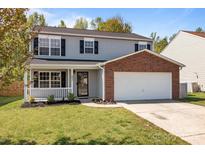 Charming two-story home with gray siding, brick accents, a covered porch, and a two-car garage at 10937 Dry Stone Dr, Huntersville, NC 28078