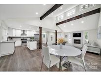 Bright and airy living room featuring a modern kitchen, vaulted ceilings and stone fireplace at 11914 Rock Canyon Dr, Charlotte, NC 28226