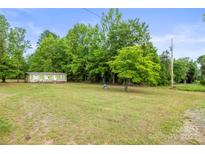 Quaint one-story home with a green lawn and ample privacy provided by mature trees at 1317 Requa Rd, Cherryville, NC 28021