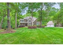 Charming home with stone and brick exterior, manicured lawn, mature trees and lush landscaping at 14131 Lea Point Ct, Huntersville, NC 28078
