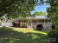 Charming home featuring a welcoming front porch with red shutters and a well-maintained front lawn at 1537 Haupt Strasse None, Conover, NC 28613