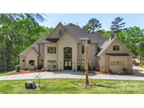 Stunning two-story stucco home featuring a spacious front yard and well-manicured landscaping at 220 Palm Cove Way, York, SC 29745