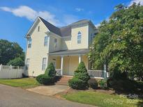 Charming two-story home with a welcoming front porch, set on a well-manicured lot with lush landscaping at 4146 Library Nw Ln, Conover, NC 28613