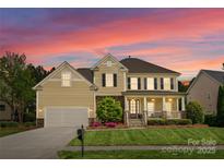 Charming two-story home with a well-manicured lawn, inviting front porch, and attached garage at 541 Nw Sutro Forest Dr, Concord, NC 28027