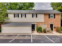 Charming townhome with brick and siding exterior, black shutters, and parking spaces at 5901 Quail Hollow Rd # G, Charlotte, NC 28210