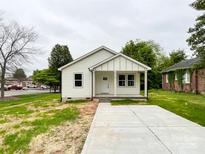 Charming single-story home with white siding, a cozy front porch, and a concrete driveway at 712 N Washington St, Shelby, NC 28150