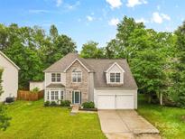 Charming two-story home featuring a stone facade, well-manicured lawn, and two-car garage at 9010 Davis Crossing Ct, Charlotte, NC 28269