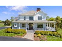 Stunning home featuring a welcoming front porch, stone walkway, and beautifully manicured landscaping at 1065 Hunter Bridge Rd, Stony Point, NC 28678