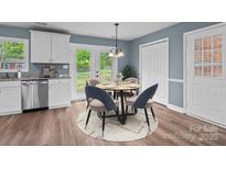 Bright dining area features stylish chairs, a modern chandelier, and view to the backyard at 1195 Ralph B Keener Rd, Lincolnton, NC 28092