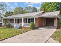 Charming single-story red brick home featuring a metal roof, a front porch, and a long concrete driveway at 1195 Ralph B Keener Rd, Lincolnton, NC 28092