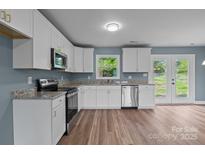 Well-lit kitchen features white cabinets, stainless appliances, and beautiful granite countertops at 1195 Ralph B Keener Rd, Lincolnton, NC 28092