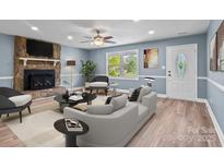 Cozy living room with stone fireplace, neutral furniture, and lots of natural light at 1195 Ralph B Keener Rd, Lincolnton, NC 28092