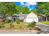 Charming single-story home with a well-manicured lawn and mature trees at 12305 Portrush Ln, Charlotte, NC 28273
