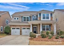 Charming two-story home with stone accents, manicured landscaping, and a two-car garage at 132 Cherry Bark Dr, Mooresville, NC 28117