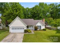 Charming single-story home with a manicured lawn, a two-car garage, and inviting front porch at 13324 Kintyre Ct, Matthews, NC 28105