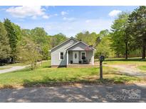 Charming single-story home with a cozy front porch, American flag, and well-maintained lawn at 146 37Th Nw St, Hildebran, NC 28601
