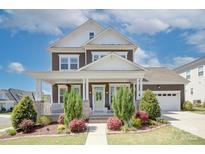 Charming two-story home with a covered front porch and well-manicured landscaping at 1528 Half Pint Loop, Fort Mill, SC 29708