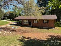 Charming single-story brick home with a welcoming front yard featuring a tree swing at 22 Heritage View Rd, Hickory, NC 28601