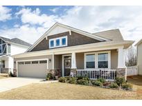 Charming home with a two-car garage, stone accents, covered porch, and beautifully landscaped front yard at 3100 Cheyney Park Dr, Charlotte, NC 28269